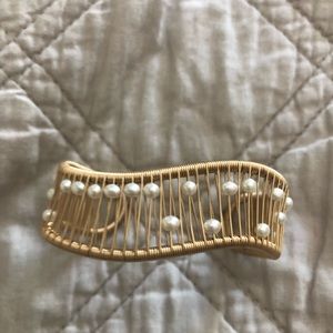 A gold wire cuff bracelet with pearl beads